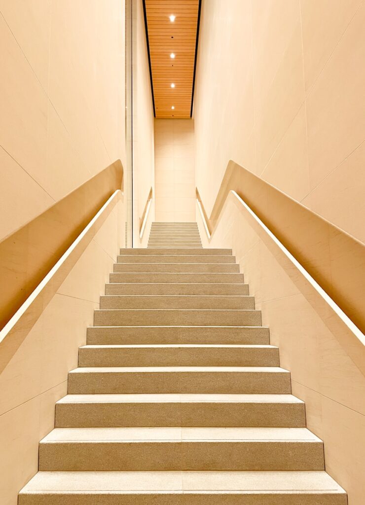 white concrete staircase with stainless steel railings